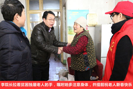 李院長拉著貧困獨居老人的手，囑咐她多注意身體，并提前祝老人新春快樂